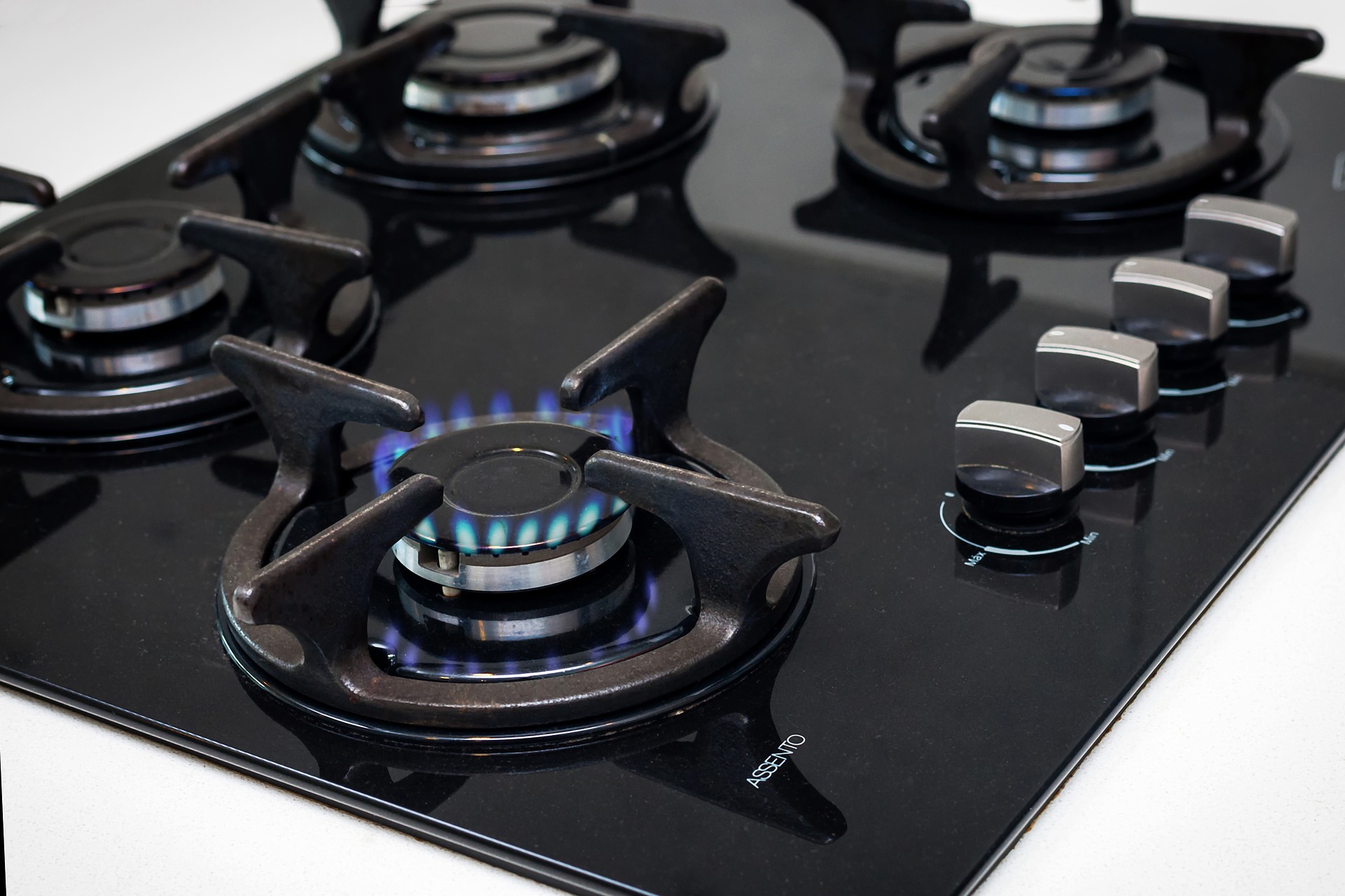 A gas stove with a burner on.