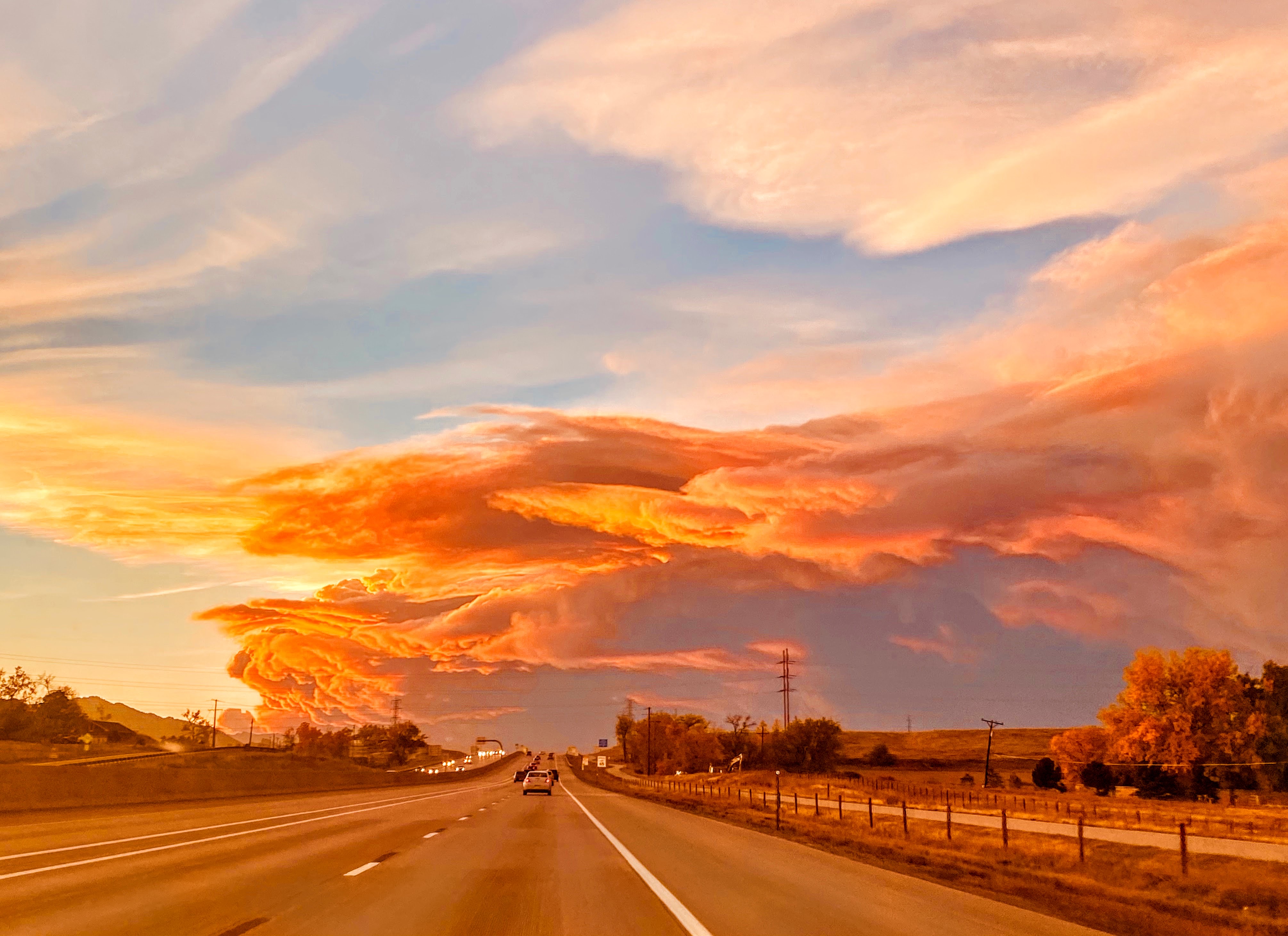 Photo of a road with pink smoke clouds stretching across the horizon.