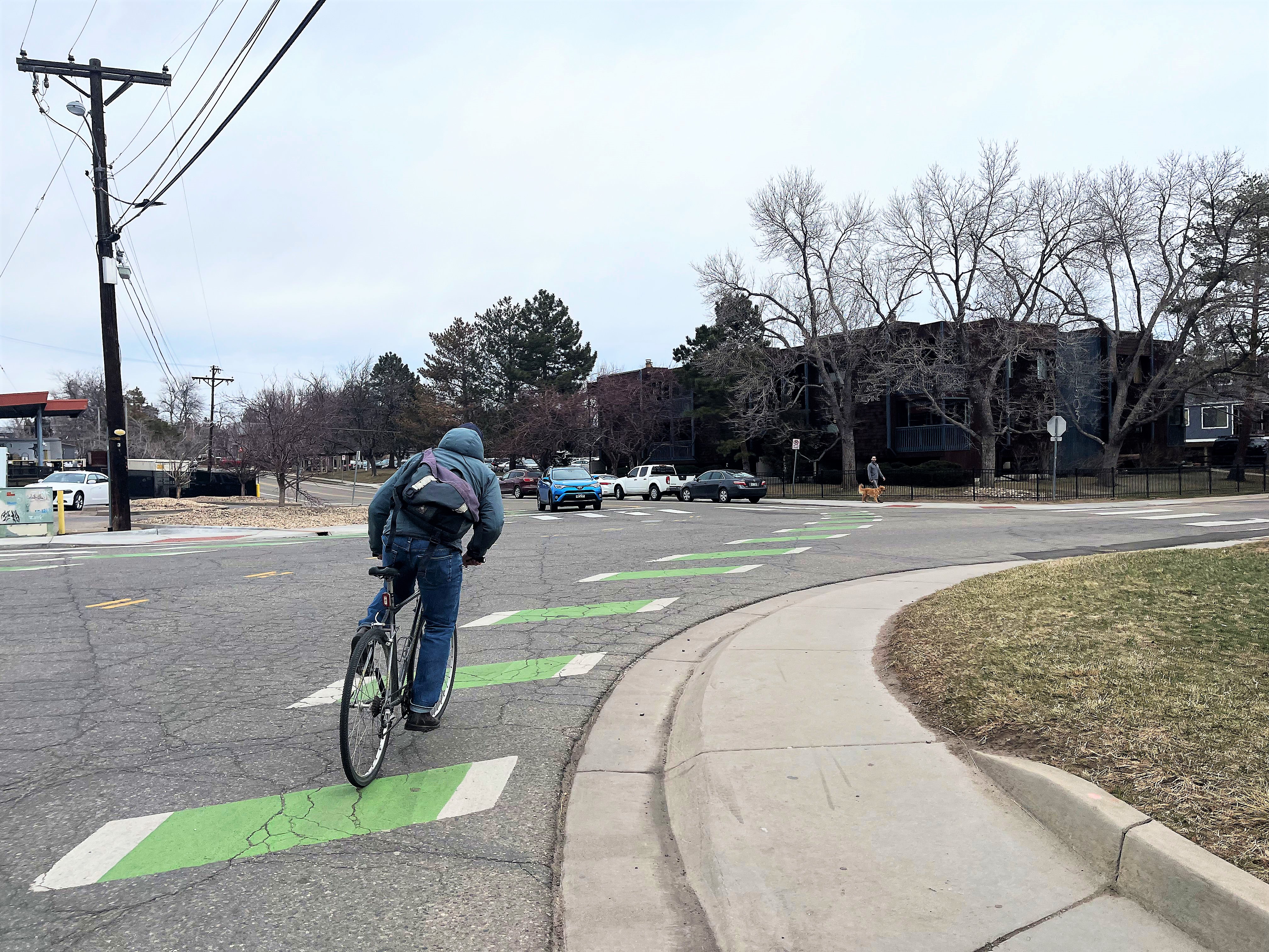 Person biking on striped green bike lane