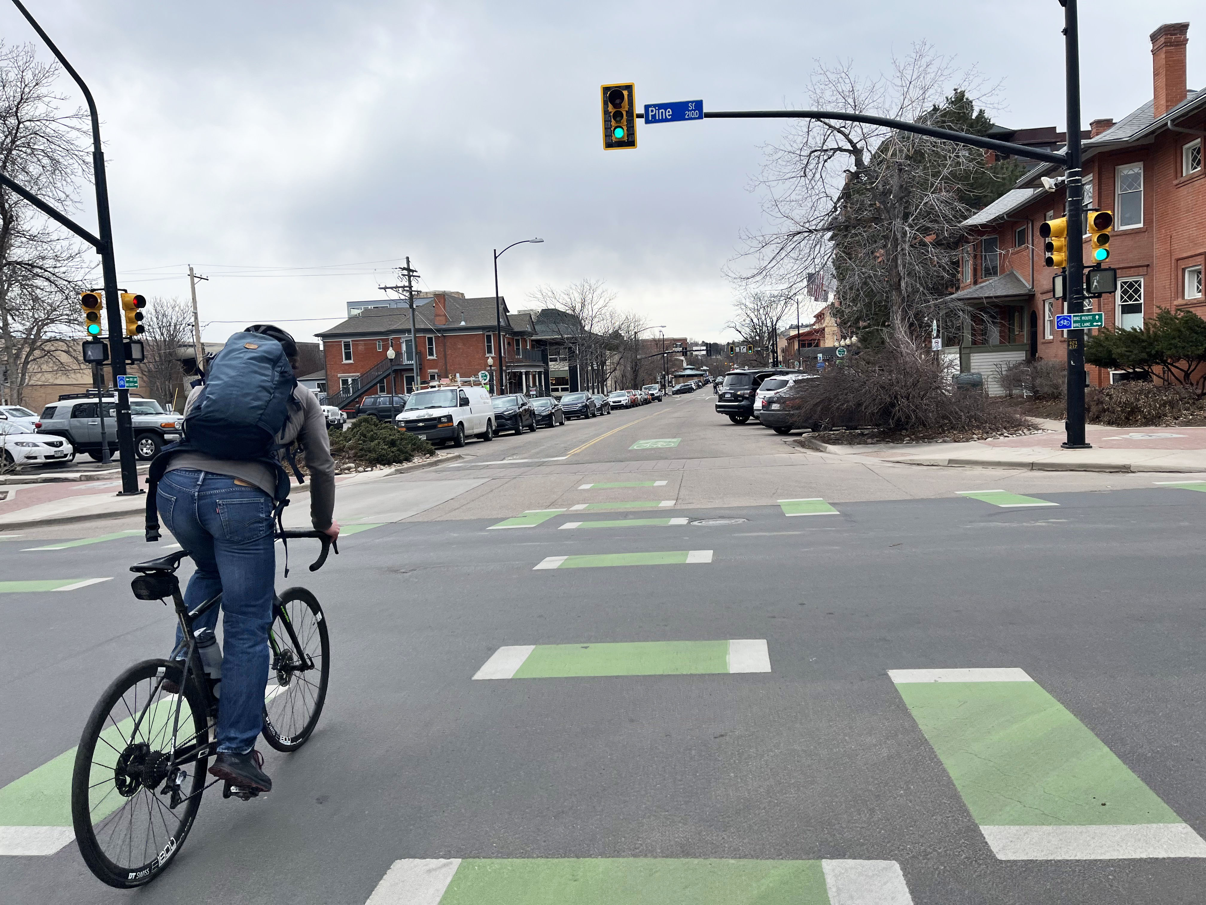 person biking on green bike lane markings in the intersection