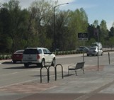 bus stop with bench next to road and bike racks