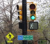 traffic light with pedestrian crossing sign, traffic pole, and signs for wayfinding